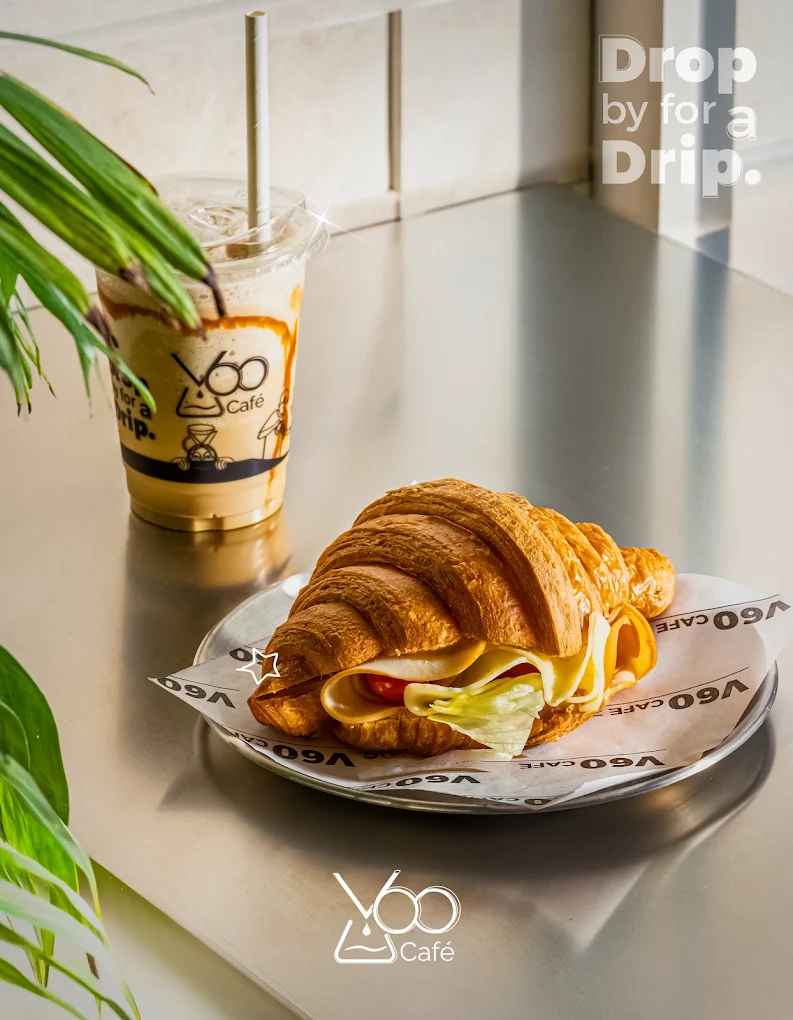 Croissant sandwich and iced coffee on a V60 Café table